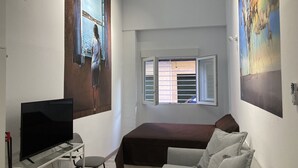 A bedroom with a bed, a TV, a desk, and a chair. - Golondrinas de Malaga (Málaga)