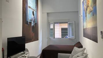 Relax in a stylish room with a flat-screen TV, comfortable bed, and large window.