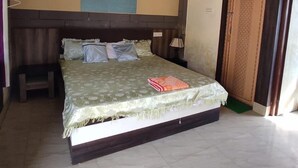 A bedroom with a bed, a ceiling fan, a wall-mounted light, and a door.