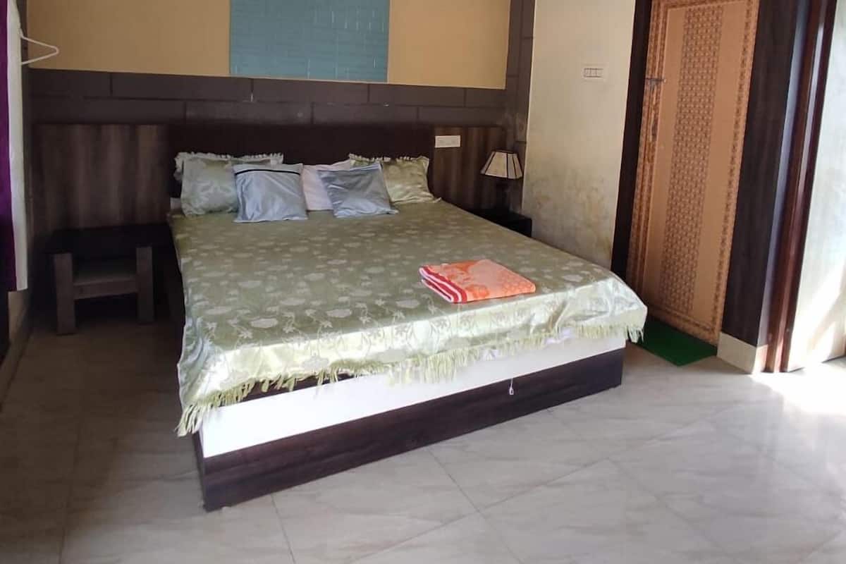 Un dormitorio con cama, ventilador de techo, luz empotrada en la pared y una puerta.
