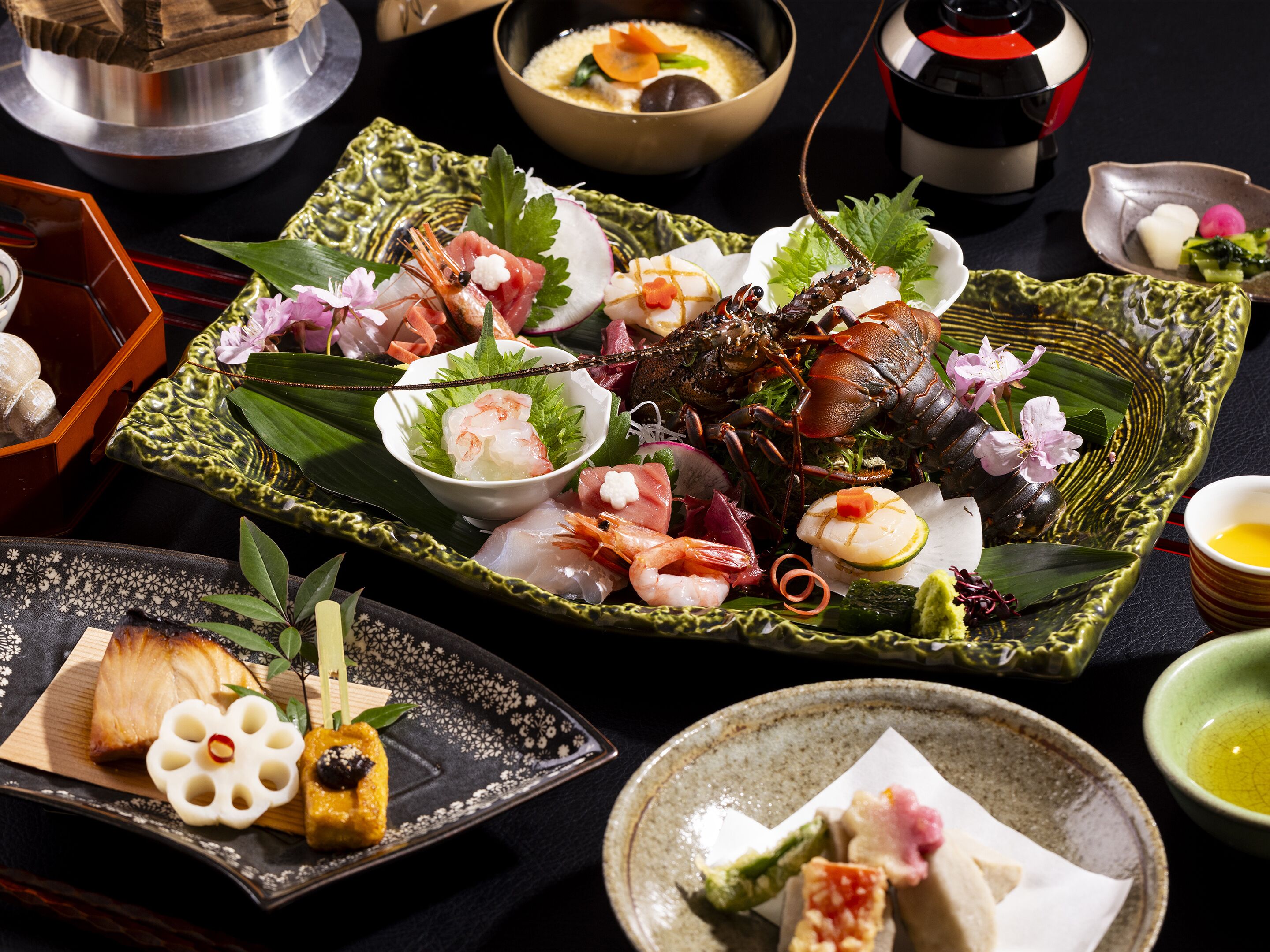 A variety of Japanese dishes on a table, including seafood and vegetables, with traditional bowls and plates.