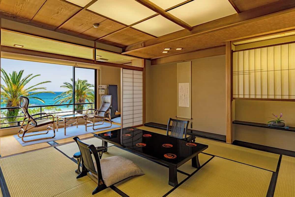 Ein traditioneller japanischer Raum mit Tatami-Böden, einem niedrigen Tisch und Blick auf das Meer.