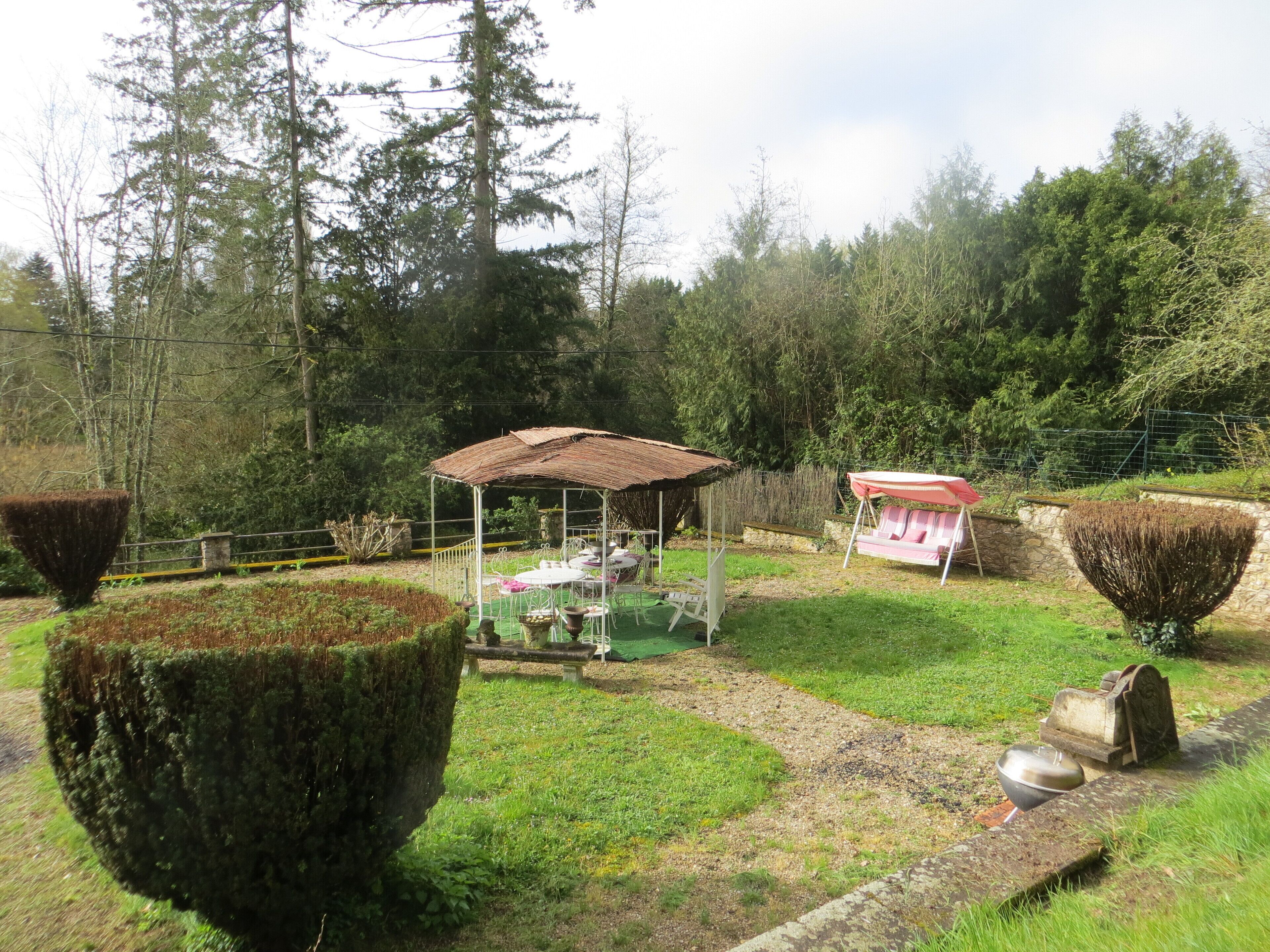 Un jardin agrémenté d’un belvédère, d’un espace détente et de haies soigneusement taillées.
