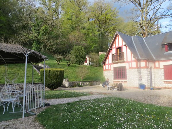 Un tradizionale chalet con facciata in pietra, un balcone e una struttura del tetto in paglia.