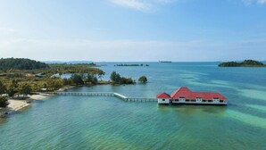 A coastal property with a pier extending into turquoise waters, surrounded by lush greenery and small islands. - Morelo Water Villa (Galang)