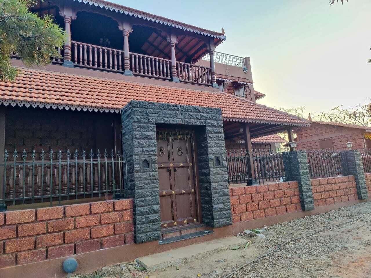 Una casa de dos pisos con techo de tejas, un balcón y una entrada con reja.