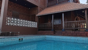 A two-story building with a swimming pool in front. - Apla Wada (Khandala)