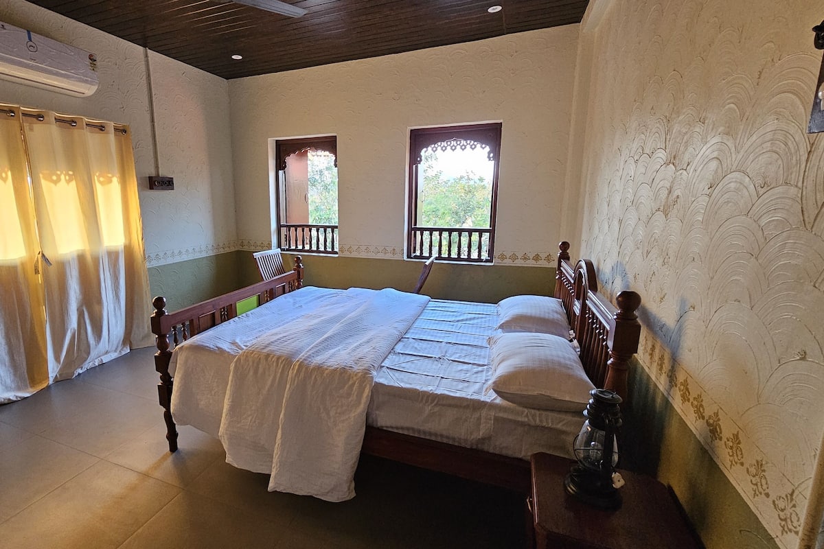 Quarto com cama de madeira, janela com vista e cortina.