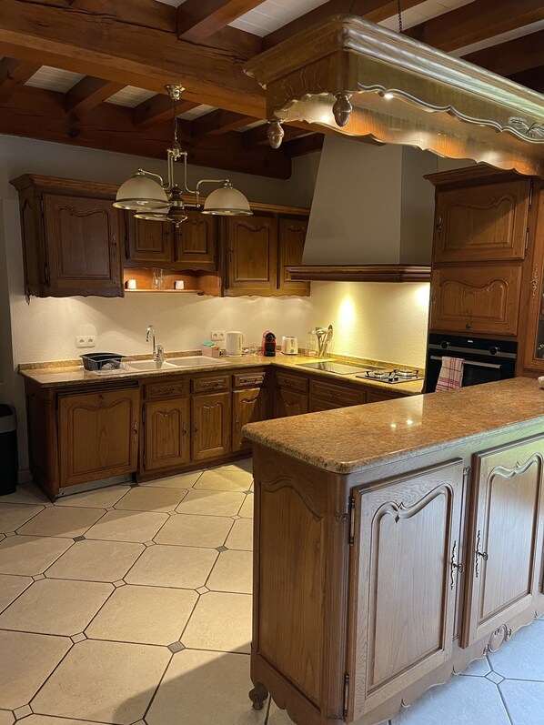 Enjoy cooking in this well-equipped kitchen with a central island, stove, oven, and sink.