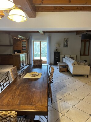 Enjoy meals in this stylish dining area with a large table for four, wicker chairs, and a comfortable sofa.