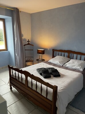 Classic four-poster bed with a bedside table and reading nook.