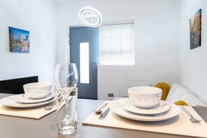 Enjoy meals in this dining area with a table for two, a window view, and a door leading to another room.