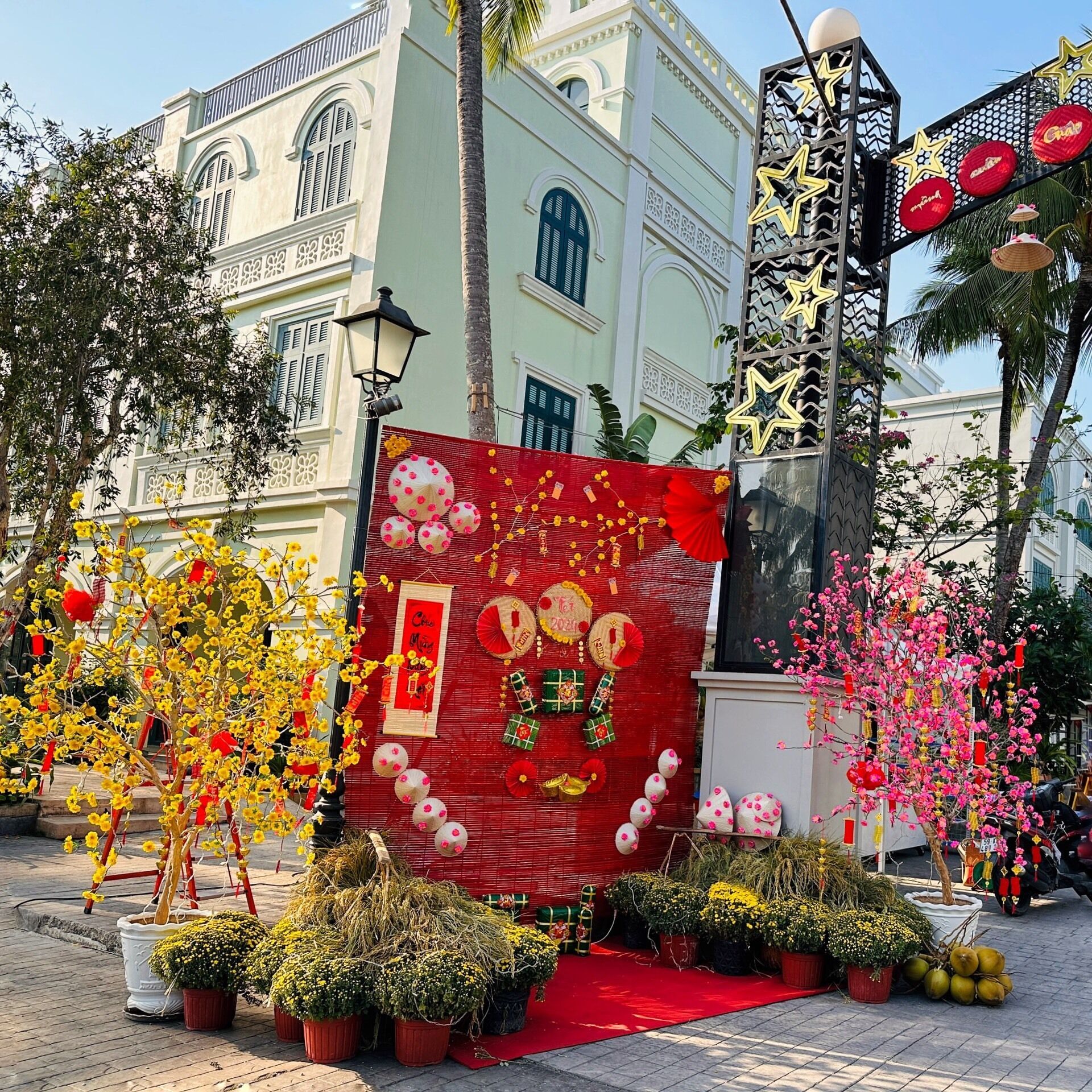 A traditional building with a red banner, potted plants, and decorative elements.