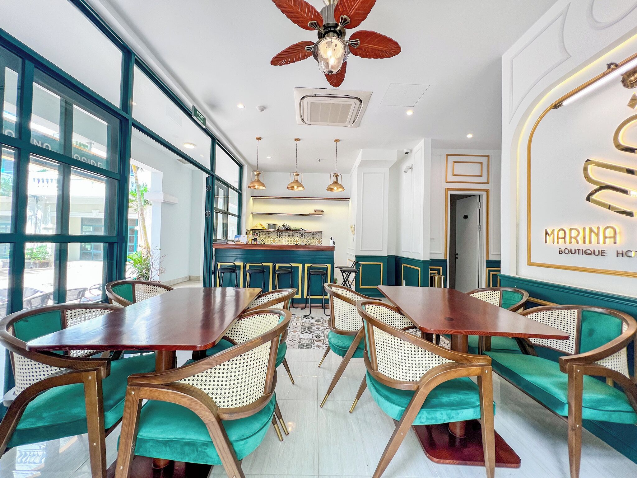 A restaurant with a modern interior, featuring wooden tables and chairs, a bar area, and large windows providing natural light.