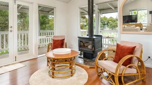 A cozy living room with a fireplace, wicker furniture, and a large mirror. - The Birkdale by Ready Set Stay- heated pool, WIFI, amazing and modern (Sunset Strip)