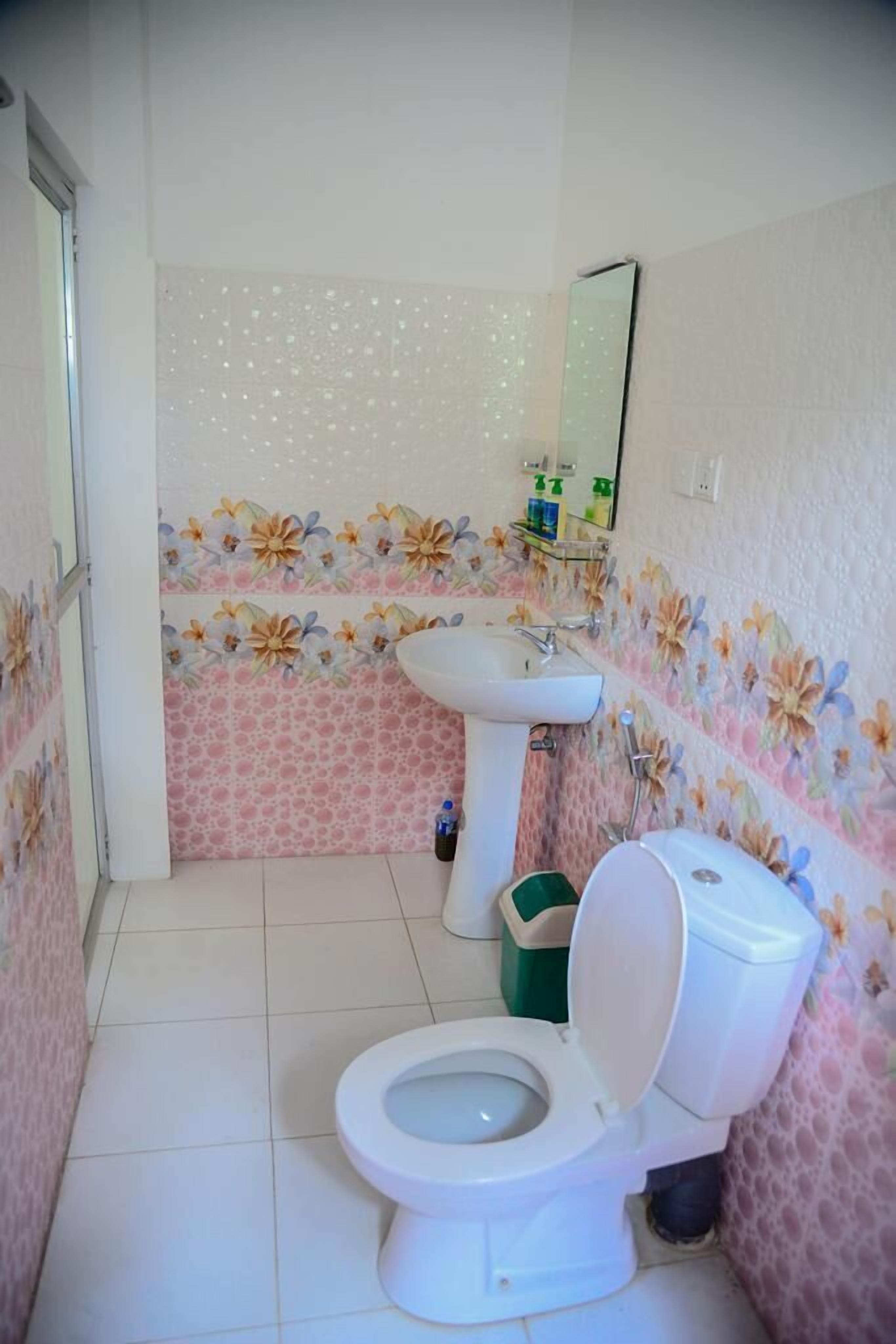 Un baño pequeño con inodoro, lavamanos y espejo.