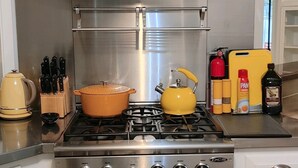 A stainless steel kitchen with a gas stove, oven, and a range hood. - Mid Century Modern Nights Dream (Houston)