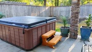 A hot tub with a wooden exterior and a bench beside it. - Mid Century Modern Nights Dream (Houston)