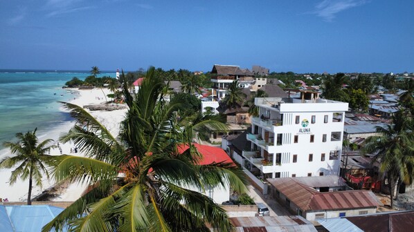 A coastal town with a beach, palm trees, and a building labeled "ALUNA BUREAU DEPARTMENTS". - Aluna Beach Apartments (Nungwi)