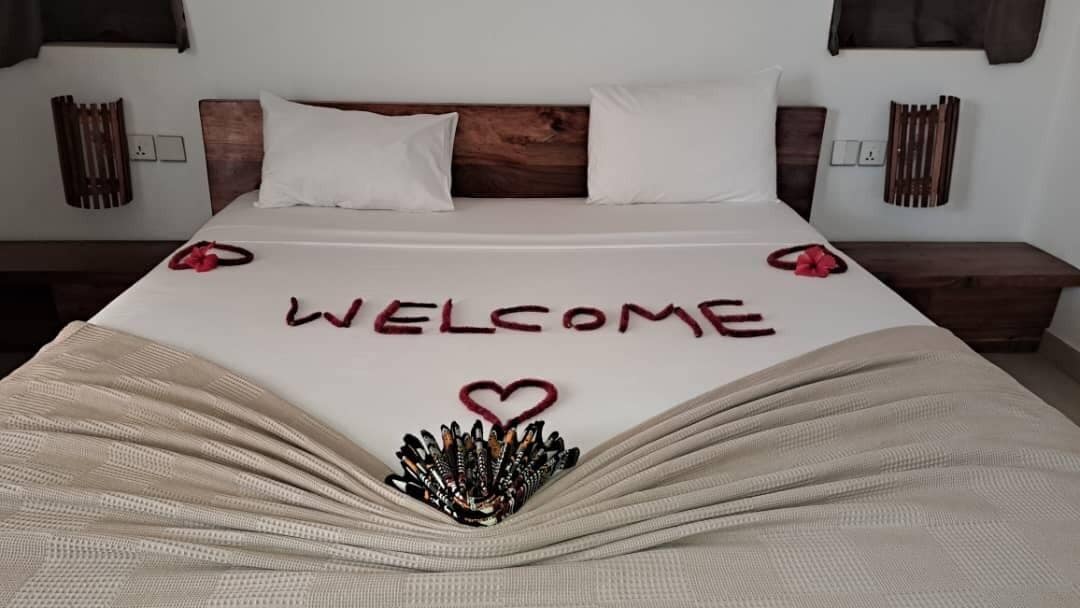 Un lit agrémenté d’un paillasson et d’une décoration en forme de cœur sur la couvre-lit.