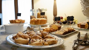 A buffet table with various pastries and desserts, including cakes and fruit. - Agriturismo Torreghiotta (Pistoia)