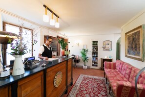 A reception area with a wooden counter, a cash register, and a potted plant. - Agriturismo Torreghiotta (Pistoia)