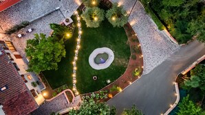 Vue aérienne d’une cour intérieure avec une fontaine centrale, entourée de chemins de pierre et de verdure.