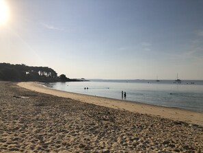 A beach with a sandy shore, calm water, and a few boats in the distance. - PORT DUN - Holiday home with sea view in Saint-Philibert - C36 (Saint-Philibert)