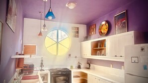 Cocina compacta con una isla central, horno empotrado y ventana con tragaluz.
