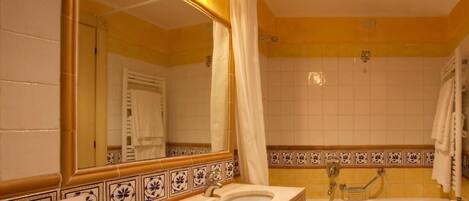 Un baño con lavabo, espejo y bañera.
