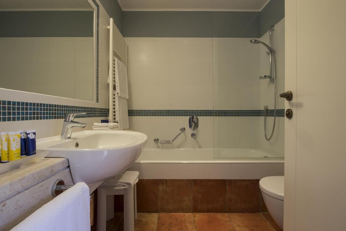 Un baño con lavamanos, bañera e inodoro.