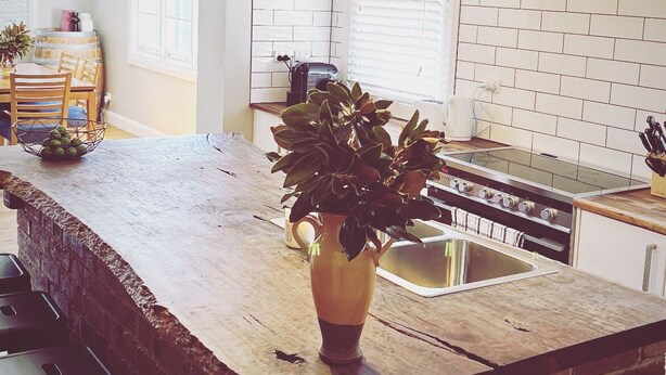 A kitchen with a brick island, hanging pendant lights, and a brick wall backsplash. - The BnB filled to the brim with character and charm! (Dubbo)