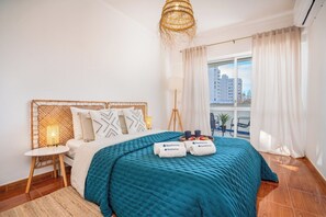 Relax in a stylish room with a large bed, wicker headboard, and city views.
