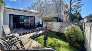 Una casa moderna amb un patí, una zona de menjador i un petit jardí.