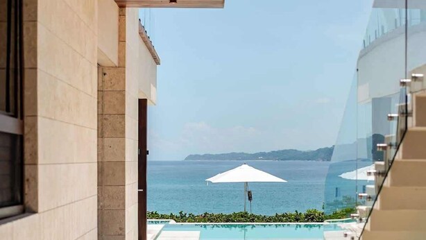 A modern outdoor swimming pool area with a view of the sea, a glass balustrade, and a wooden ceiling. - Casa Colmena: Luxury 6BR Villa w/ Infinity Pool (Corral del Risco)