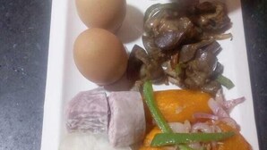 Ein Teller mit verschiedenen Speisen, darunter Reis, Eier, Fleisch und Gemüse.