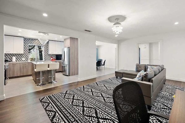 A modern apartment with a kitchen, dining area, and living room.