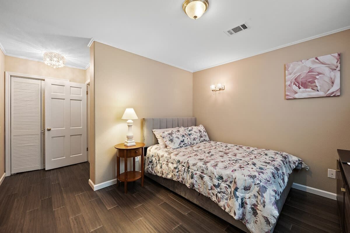 Une chambre à coucher avec un lit, une lampe de chevet et un tableau au mur.