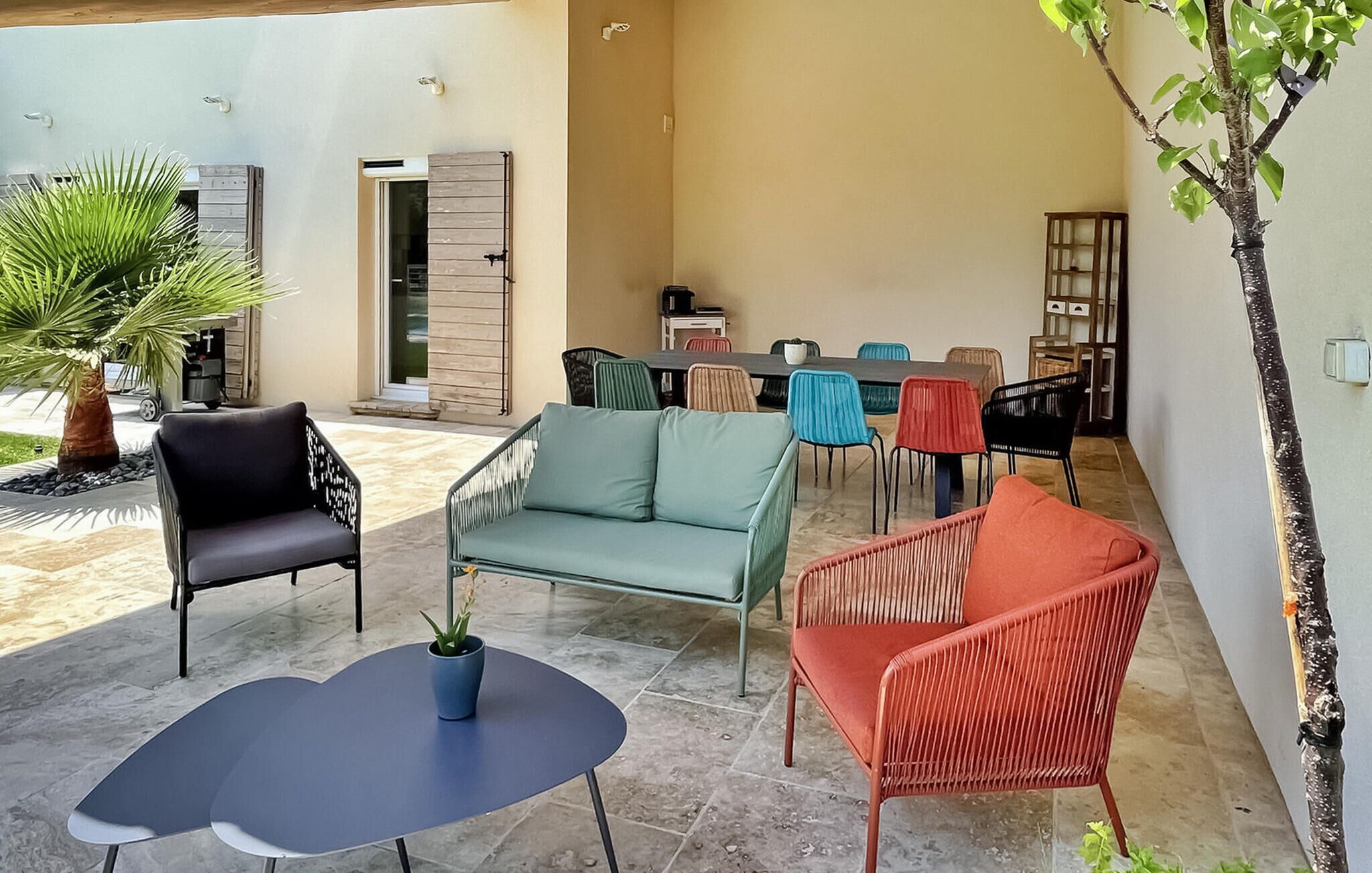 A patio area with seating, a dining table, and a small plant.