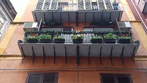 A building with a balcony with potted plants and a metal railing. - Jacona 365 Apartment - In the historic center area of Palermo. (Palermo)