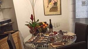 A dining table set with various foods and drinks, surrounded by chairs. - Jacona 365 Apartment - In the historic center area of Palermo. (Palermo)