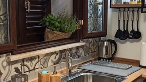 A kitchen with a stainless steel sink, a coffee maker, and a window with a plant. - Jacona 365 Apartment - In the historic center area of Palermo. (Palermo)