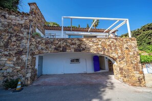 Ein Steinhaus mit einem weißen Obergeschoss und einem Untergeschoss mit einer blauen Tür.
