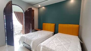 Habitación de hotel con dos camas, un espejo grande y vista al exterior.