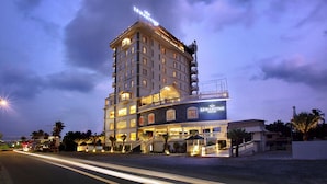 A multi-story hotel with a prominent sign, multiple balconies, and a well-lit entrance. - LE MARITIME KOCHI (Kochi)