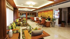 A hotel lobby with seating areas, a reception desk, and a large painting on the wall. - LE MARITIME KOCHI (Kochi)