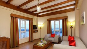 A living room with wooden beams, a sofa, a coffee table, and a TV. - LE MARITIME KOCHI (Kochi)