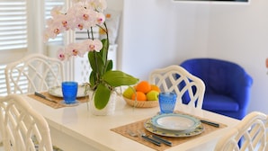 Un tavolo imbandito con piatti, posate e un vaso di orchidee.