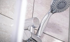 Un pommeau de douche au design circulaire et dotĂ© dâune seule commande.