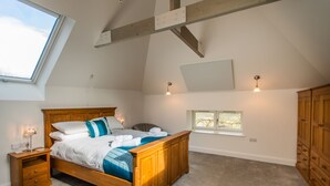 Une chambre à coucher avec un lit en bois, une table de chevet, une fenêtre et une armoire.